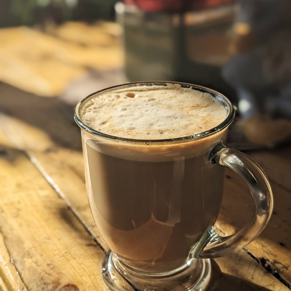 Un latté servi dans un verre à anse, mousse épaisse