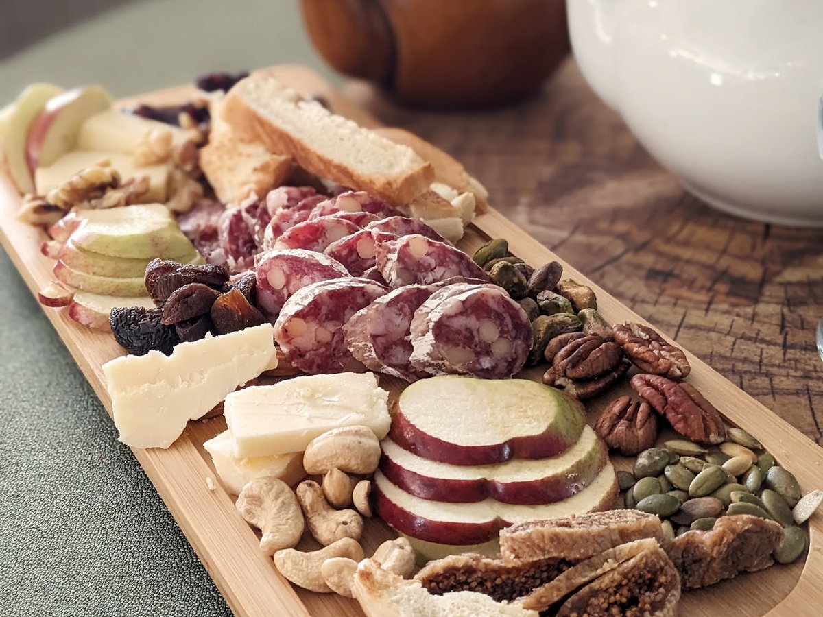 Une planche de charcuteries et de fromages avec une théière