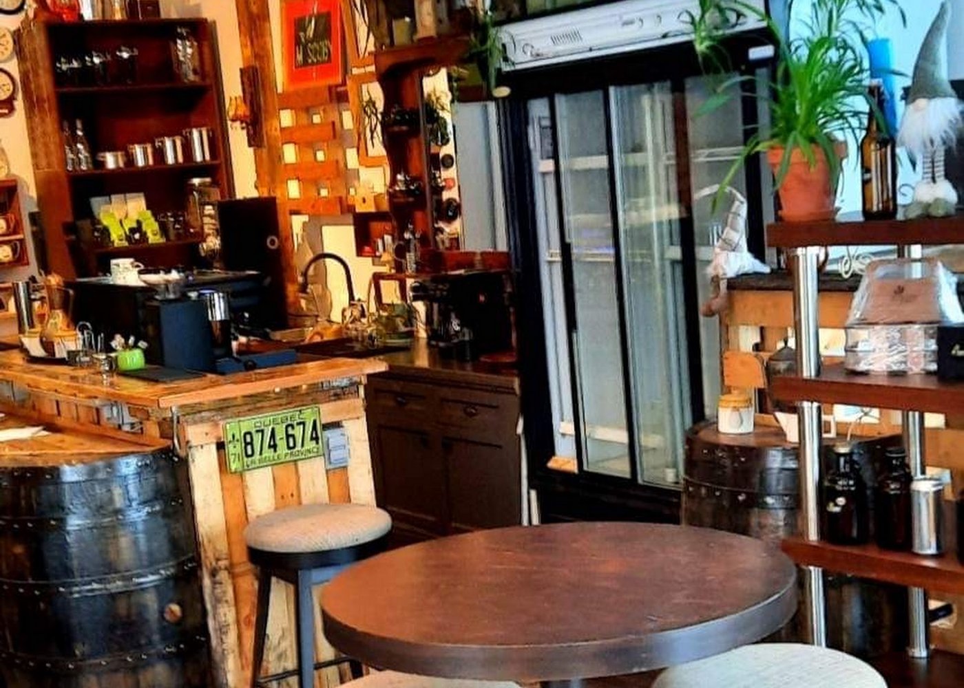 La salle de M.Scoby : étagères de bois, plantes, barriques et tables basses